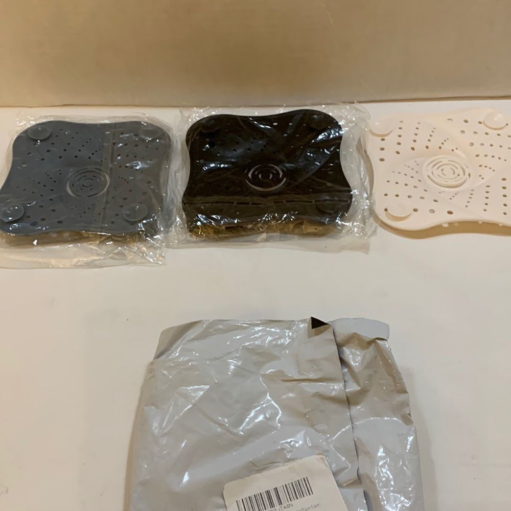 Shower drain stoppers.  Set of three: black, gray and white